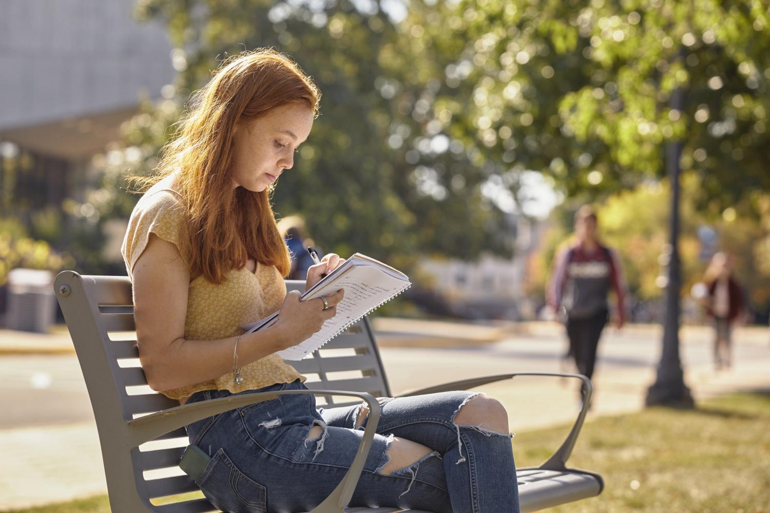一位<a href='http://hnth.ngskmc-eis.net'>全球十大赌钱排行app</a>学院的学生在校园里的长椅上读书.
